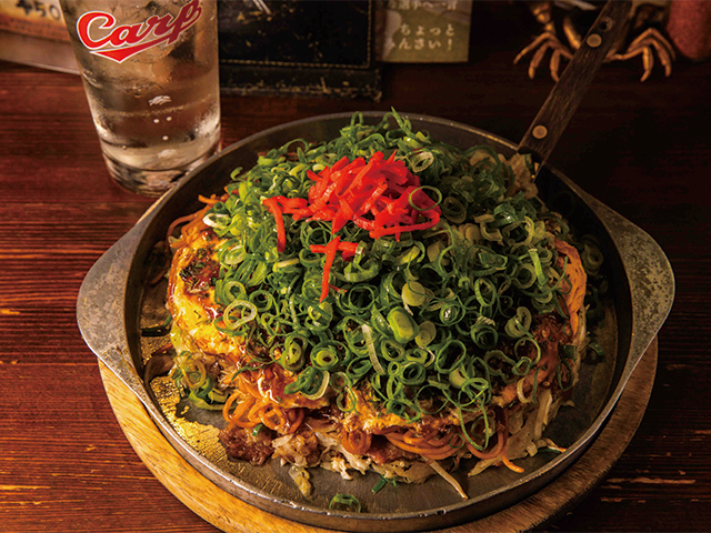 お好み焼き（750円）は、中に入れる麺をそば、うどん、辛麺の３種類から選べる。写真は店おすすめのトッピング、イカ天とネギを加えたもの（1050円）。
